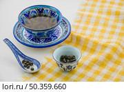 close up oolong tea cup with spoon tablecloth against white background. Стоковое фото, агентство Ingram Publishing / Фотобанк Лори