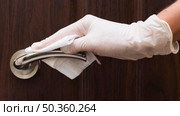 hand with glove disinfecting door handle. Стоковое фото, агентство Ingram Publishing / Фотобанк Лори