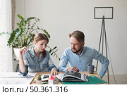 woman holding spectacle looking interior catalog with her male coworker office. Стоковое фото, агентство Ingram Publishing / Фотобанк Лори