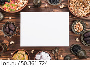 blank white paper surrounded with mix dried fruits dates lukum baklava nuts wooden desk ramadan. Стоковое фото, агентство Ingram Publishing / Фотобанк Лори