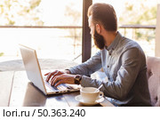 side view man typing laptop keypad with cup coffee desk. Стоковое фото, агентство Ingram Publishing / Фотобанк Лори