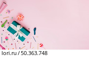 wrapped green gift box with ribbon bow balloon stickers prop colorful candles pink background. Стоковое фото, агентство Ingram Publishing / Фотобанк Лори