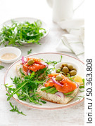 Open sandwiches with salted salmon, avocado, olives and arugula. Breakfast. Стоковое фото, агентство Ingram Publishing / Фотобанк Лори