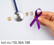 OLYMPUS DIGITAL CAMERA. close up hand with purple ribbon stethoscope. Стоковое фото, агентство Ingram Publishing / Фотобанк Лори