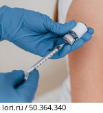 doctor with gloves preparing syringe with vaccine. Стоковое фото, агентство Ingram Publishing / Фотобанк Лори