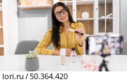 female vlogger home with smartphone make up products. Стоковое фото, агентство Ingram Publishing / Фотобанк Лори