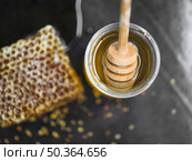 OLYMPUS DIGITAL CAMERA. honeycomb piece honey pot with wooden dipper black backdrop. Стоковое фото, агентство Ingram Publishing / Фотобанк Лори