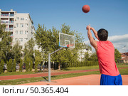 basketball player attempting distance throw. Стоковое фото, агентство Ingram Publishing / Фотобанк Лори