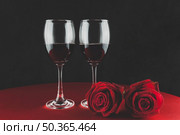botella de vino con dos copas y una rosa encima de una mesa. Стоковое фото, агентство Ingram Publishing / Фотобанк Лори