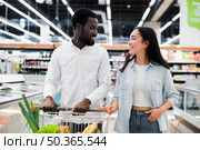 cheerful multiracial couple with shopping cart supermarket. Стоковое фото, агентство Ingram Publishing / Фотобанк Лори