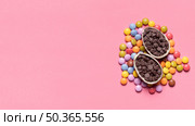 choco chips filled easter eggs gem candies pink background. Стоковое фото, агентство Ingram Publishing / Фотобанк Лори