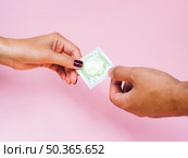 OLYMPUS DIGITAL CAMERA. close up man woman holding green condom. Стоковое фото, агентство Ingram Publishing / Фотобанк Лори