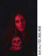 man red light shades sitting dark with skull. Стоковое фото, агентство Ingram Publishing / Фотобанк Лори