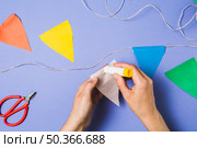person hand sticking bunting paper with glue stick. Стоковое фото, агентство Ingram Publishing / Фотобанк Лори