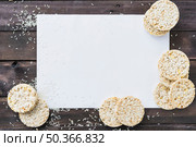 rice grains puffed rice cake white blank paper wooden desk. Стоковое фото, агентство Ingram Publishing / Фотобанк Лори