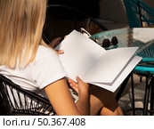 OLYMPUS DIGITAL CAMERA. woman reading mock up magazine. Стоковое фото, агентство Ingram Publishing / Фотобанк Лори