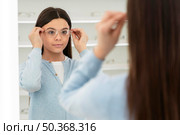 portrait girl eyeglasses store trying glasses. Стоковое фото, агентство Ingram Publishing / Фотобанк Лори