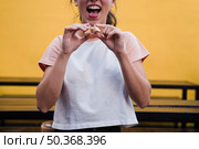portrait young woman cracking fortune cookie reveal message. Стоковое фото, агентство Ingram Publishing / Фотобанк Лори