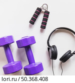 purple dumbbells headphone hand grip white backdrop. Стоковое фото, агентство Ingram Publishing / Фотобанк Лори