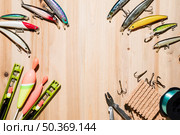 frame made with fishing lure fishing float plier hooks wooden backdrop. Стоковое фото, агентство Ingram Publishing / Фотобанк Лори