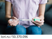 midsection view woman s hand holding thermometer. Стоковое фото, агентство Ingram Publishing / Фотобанк Лори