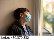 side view little boy with medical mask looking away. Стоковое фото, агентство Ingram Publishing / Фотобанк Лори