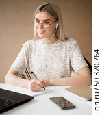 woman taking notes smiles. Стоковое фото, агентство Ingram Publishing / Фотобанк Лори