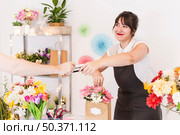female florist accepting credit card from her customer. Стоковое фото, агентство Ingram Publishing / Фотобанк Лори