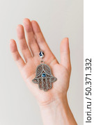 hand holding hamsa pendant. Стоковое фото, агентство Ingram Publishing / Фотобанк Лори
