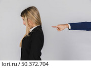 businessman s hand blaming young businesswoman against grey backdrop . Стоковое фото, агентство Ingram Publishing / Фотобанк Лори