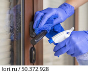 hands disinfecting door handle with ablution cloth. Стоковое фото, агентство Ingram Publishing / Фотобанк Лори