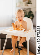 baby boy eating pasta his highchair. Стоковое фото, агентство Ingram Publishing / Фотобанк Лори