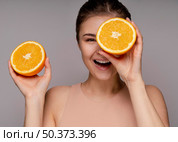 beautiful woman holding halved orange. Стоковое фото, агентство Ingram Publishing / Фотобанк Лори