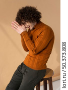 curly haired man with brown blouse posing. Стоковое фото, агентство Ingram Publishing / Фотобанк Лори