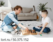 tutor learning boy how play chess. Стоковое фото, агентство Ingram Publishing / Фотобанк Лори