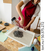 woman putting grinded paper pulp water wooden desk. Стоковое фото, агентство Ingram Publishing / Фотобанк Лори