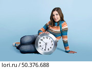 Beautiful woman seated on the ground holding a clock. Стоковое фото, агентство Ingram Publishing / Фотобанк Лори