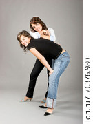 Two young beautiful sisters having fun - This models are true twins. Стоковое фото, агентство Ingram Publishing / Фотобанк Лори