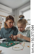 Girl learns to create resin art under mothers guidance, developing concentration and creative thinking while playing and experimenting with colors and shapes. Стоковое видео, видеограф Енваев Андрей / Фотобанк Лори