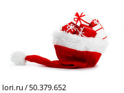 A red santa hat with gifts isolated on white background. Стоковое фото, агентство Ingram Publishing / Фотобанк Лори