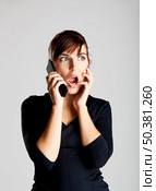 Astonished young woman listening the news at the cellphone. Стоковое фото, агентство Ingram Publishing / Фотобанк Лори