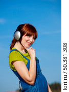 Portrait of a happy woman listen music over a beautiful blue sky. Стоковое фото, агентство Ingram Publishing / Фотобанк Лори