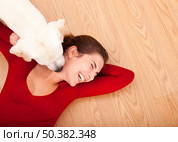 Woman lying on the floor and her dog licking her face. Стоковое фото, агентство Ingram Publishing / Фотобанк Лори