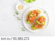 Open sandwiches with salted salmon, guacamole avocado and microgreens. Seafood. Healthy food. Top view. Стоковое фото, агентство Ingram Publishing / Фотобанк Лори