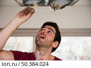 close up male electrician installing holder ceiling light. Стоковое фото, агентство Ingram Publishing / Фотобанк Лори