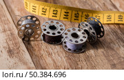 high angle sewing machine shuttles with measuring tape. Стоковое фото, агентство Ingram Publishing / Фотобанк Лори