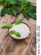raw white rice bowl with fresh basil leaves weathered wooden plank. Стоковое фото, агентство Ingram Publishing / Фотобанк Лори