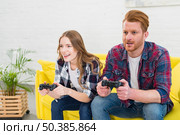 young couple having fun playing videogame home. Стоковое фото, агентство Ingram Publishing / Фотобанк Лори
