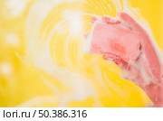 OLYMPUS DIGITAL CAMERA. close up hand wearing pink gloves washing yellow backdrop with sponge. Стоковое фото, агентство Ingram Publishing / Фотобанк Лори