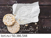 crumpled paper with two round puffed rice cake with grains wooden desk. Стоковое фото, агентство Ingram Publishing / Фотобанк Лори